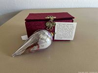 Teardrop glass ornament, velvet box, information card visible