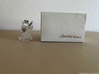 Blown glass angel figurine beside Gemstone Books box