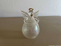 Front view of small iridescent glass angel figurine with gold halo and wings