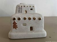 Front view showing gold-tone windows, ladder motif, tree design and Pueblo house shape