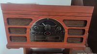 Front view of Crosley wood stereo system showing radio dial and speaker grilles