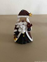 Front view of resin Santa figurine holding lantern and cardinal