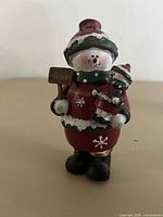 Front view of resin snowman figurine with sign and smaller figure