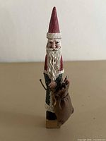 Front view of tall resin Santa figurine with sack