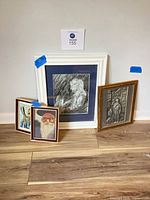 Group shot of all four framed artworks standing against wall