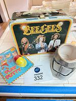 Front view of Bee Gees lunchbox, Play Putty egg, Stormtrooper mug