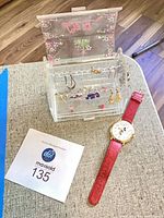 Overview of lucite box with earrings and Mickey watch