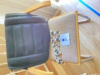 Armchair with cushion and necklaces on seat, view from side