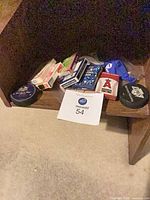 Overall view of decks of cards, two hockey pucks and pouch on shelf
