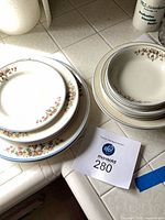 Two stacks of assorted floral china plates and bowls