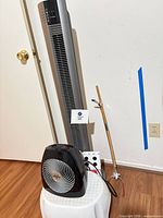 Full view of tower fan, Vornado fan on step stool, power strip and wooden pole