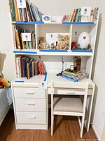 Front view of white desk with hutch shelving and chair