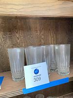 Front view of six water tumblers on shelf