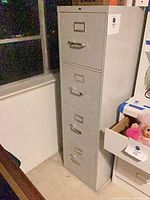Front view of grey four-drawer metal filing cabinet