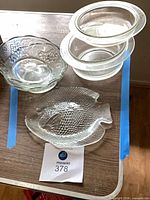 All four glass items: fish platter, two grape-pattern bowls, covered casserole