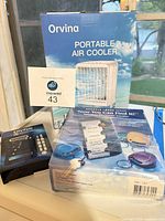 All three boxed items together: air cooler, locator kit, battery tester