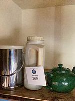Ice bucket, thermos, and teapot side by side on shelf