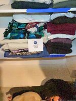 Shelf with approx. ten folded women’s garments and one packaged molded piece