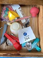 Drawer view showing majority of lot contents including spoons, thermometers, baster, candles, cups, wine opener