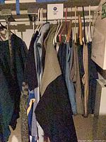 Clothing on closet rod showing variety of shirts and jackets