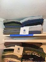 Stacked folded T-shirts upper and lower shelves