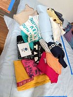Pile of assorted women’s clothing on bed