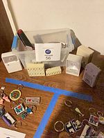 Group view of night lights and wall tap adapters on tabletop within blue tape