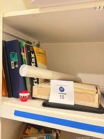 Shelf with binder, columnar pad, folders, paper roll, letter tray, red figurine