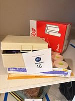 Shelf with Office Depot bond roll box, loose fax rolls, beige organizer and copy paper