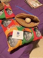 Two Shohei Ohtani pillows, baseball glove and baseball displayed together