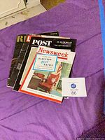 Stack of magazines showing Newsweek on top with other titles beneath