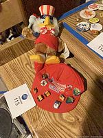 Plush eagle, red cap and pins on tabletop