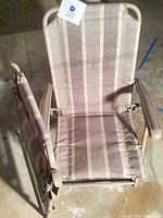 Chair open showing striped padded fabric seat and back, armrests and metal frame