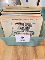 Front view of bin containing stack of soundtrack and show-tune LPs; top album Man of La Mancha visible