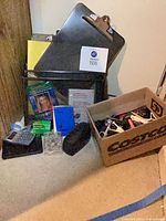 Overall lot showing mesh basket with various office supplies and box of staplers