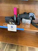 Group view of all items: two cameras, lens, three flashlights, two cases