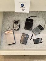 Six pocket radios arranged on countertop