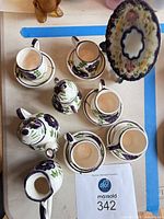 Top view of ceramic tea set components and decorative plate