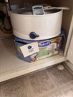 Bonnet dryer unit resting atop original Conair Perfect Fit box inside cabinet