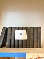 Front view of 10 matching hardcover books standing upright on shelf