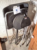 Overall lot showing the three folded seating items leaning against wall