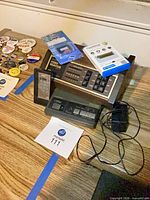 Overview showing video selector, answering machine, memory devices, pin buttons and power adapter