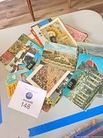 Pile of assorted vintage postcards with two black combination padlocks visible