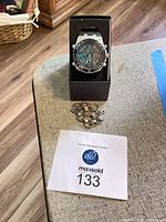 Watch in presentation box with chain and lot tag visible