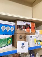 Shelf with multiple boxed light bulbs including GE Crystal Clear, GE Bug Light and others