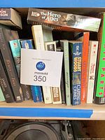 Shelf of mixed books with lot tag visible