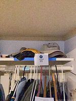 Four accessories on shelf: bucket hat, fanny pack and hats visible