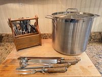 Stock pot, ladle, carving set, flatware caddy on cutting board