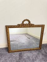 Front view of gilded rectangular mirror with crest