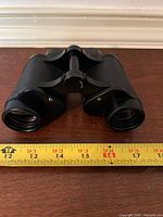 Front view showing objective lenses, hinge and focus knob, ruler for scale